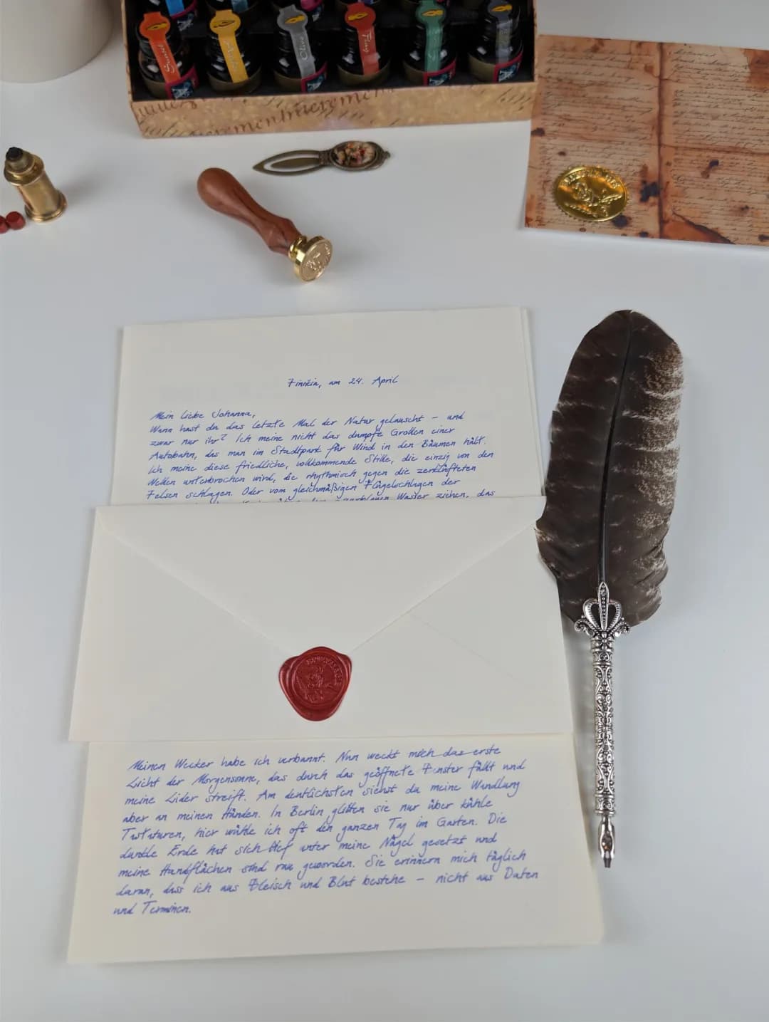 Handgeschriebener Brief „Finikia, am 24. April“, versiegelter Umschlag, Feder und Tintenkasten auf hellem Tisch